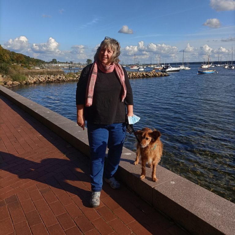Frau mit Hund vor Wasser